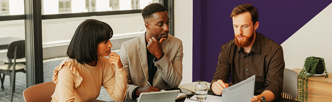 Man and woman sitting down with a banker reviewing borrowing products and solutions